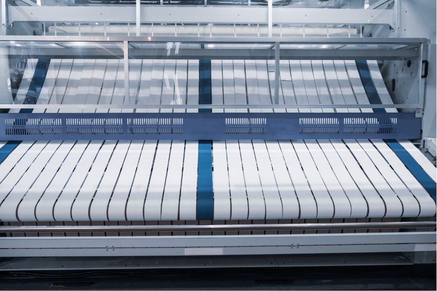 Automatic industrial towel folder processing linens in a high-volume laundry
